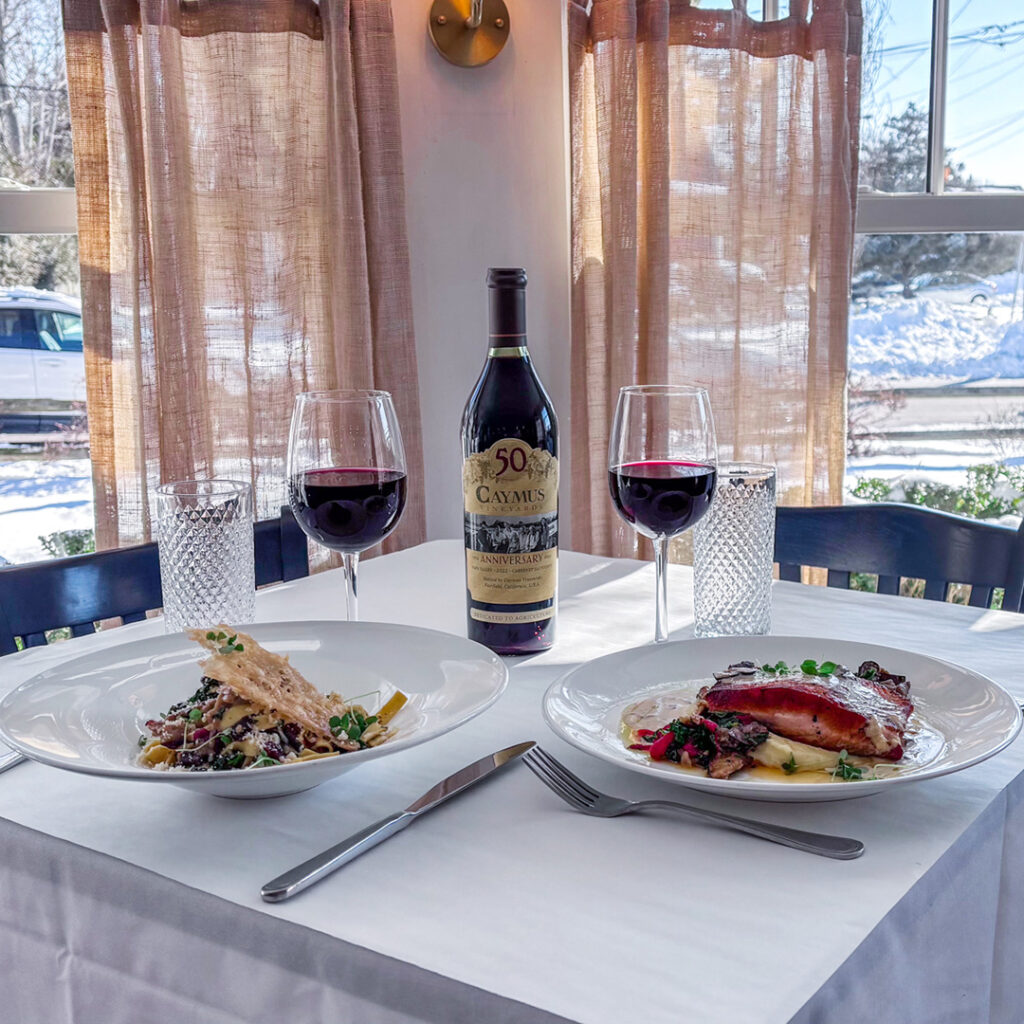 Wine Down Wednesday at Fauna. Salmon and Duck Pasta with Caymus Bottle of red Wine and two glasses poured.