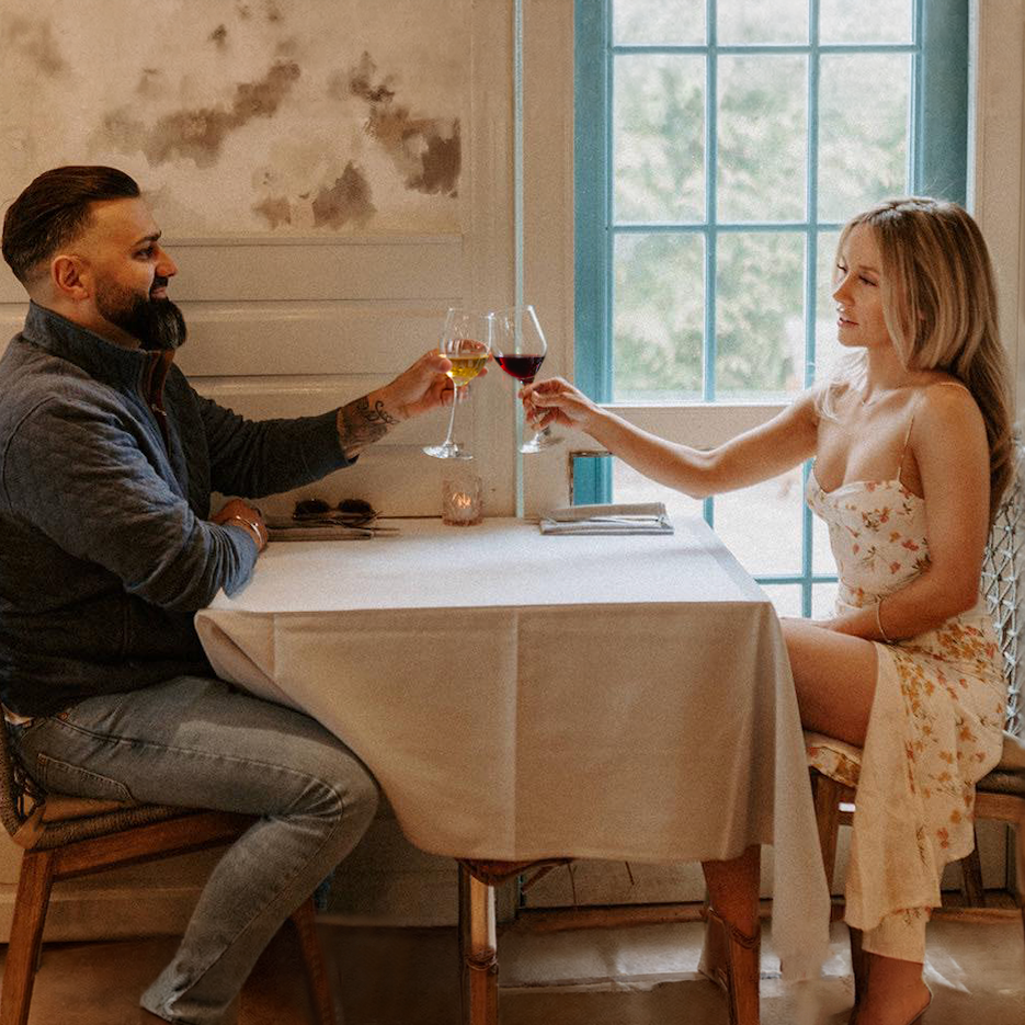 flora Charlotte: Wine Down Wednesday. Two Guests cheering wine glasses.