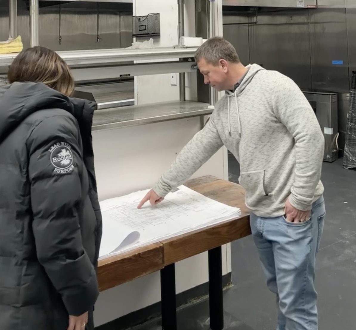 David Hersh reviewing blueprints with Rachel Hersh in the kitchen during the build-out of flora Charlotte